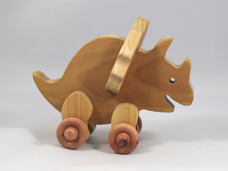 Handmade wooden push toy Triceratops dinosaur made from select grade hardwoods and finished with a non-toxic coating.