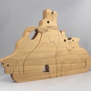 Wooden Wolf Family Stacking Puzzle is handmade from hardwood and finished with mineral oil, beeswax, and carnauba wax. Freestanding interlocking wolf family puzzle pieces shown assembled. Approximate size 10.5 inches long by 6.7 inches high by 3/4 inch thick. Handmade in Tallahassee, Florida, USA.