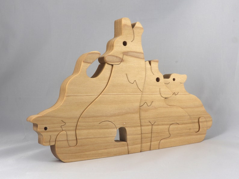 Wooden Wolf Family Stacking Puzzle is handmade from hardwood and finished with mineral oil, beeswax, and carnauba wax. Freestanding interlocking wolf family puzzle pieces shown assembled. Approximate size 10.5 inches long by 6.7 inches high by 3/4 inch thick. Handmade in Tallahassee, Florida, USA.