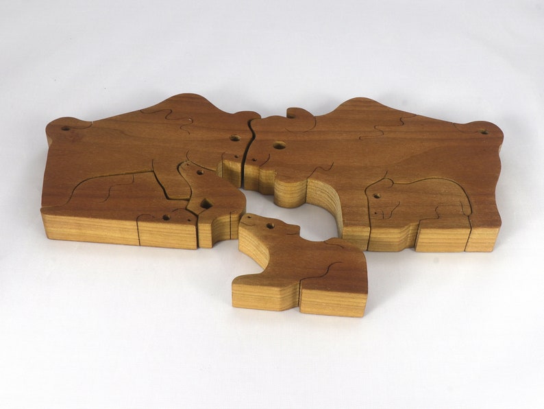 Wooden 6-piece bison family puzzle with two adult bison and four calves. The hardwood pieces interlock into one standing group or separate to stand alone. Handnmade in Tallahassee, Florida, USA by Odin's Toy Factory.