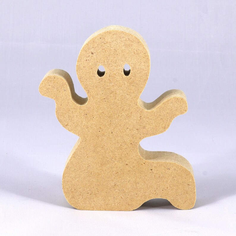 A handmade, unpainted wooden ghost cutout stands upright on a white background. The light-colored solid wood figure has a rounded head with two circular eye cutouts, raised wavy arms, and a curved wavy base, ready for painting or crafting.