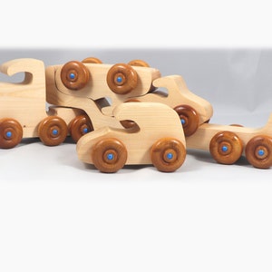 Handmade wooden toy truck play set includes three cars and a tractor-trailer finished with clear and amber shellac with metallic sapphire blue trim.