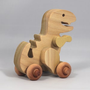 Handmade wooden push toy Tyrannosaurus Rex dinosaur made from select grade hardwoods and finished with a non-toxic coating.
