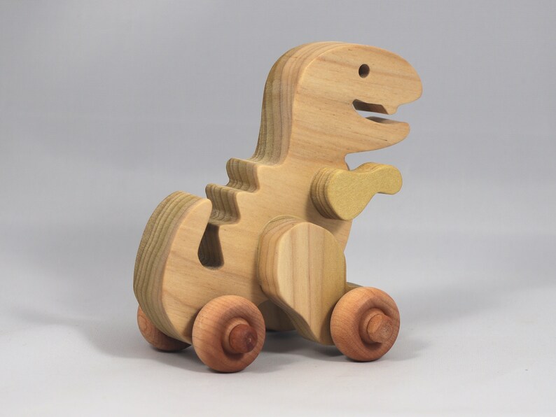 Handmade wooden push toy Tyrannosaurus Rex dinosaur made from select grade hardwoods and finished with a non-toxic coating.