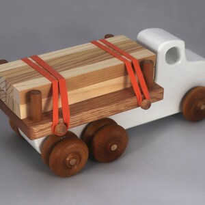 Handmade wooden toy lumber truck from Odin's Toy Factory Easy 5 Truck Fleet Collection. Painted lumber truck with acrylic body, shellac bed, and wheels. Measures approximately 9 inches long, 4 inches high, and 3.5 inches wide. Handmade in Tallahassee, Florida, USA. Custom colors available.