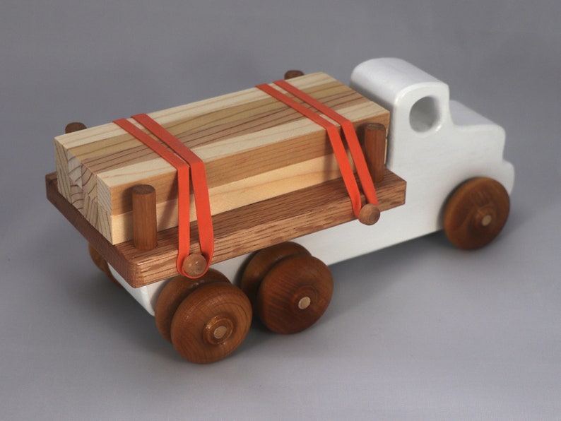 Handmade wooden toy lumber truck from Odin's Toy Factory Easy 5 Truck Fleet Collection. Painted lumber truck with acrylic body, shellac bed, and wheels. Measures approximately 9 inches long, 4 inches high, and 3.5 inches wide. Handmade in Tallahassee, Florida, USA. Custom colors available.