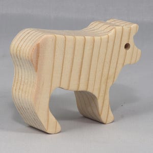 This is an unfinished wooden Calf cutout from solid wood using traditional woodworking techniques. Sanded smooth and ready to paint, stain, or customize. Freestanding design for small hands, toddlers, young children, crafters, collectors, and display. I take custom orders for any animal, quantity, and mix — including large ornament orders. Mix and match, request a different size, or send a drawing or pattern. Handmade by Odin's Toy Factory in Tallahassee, Florida, USA.