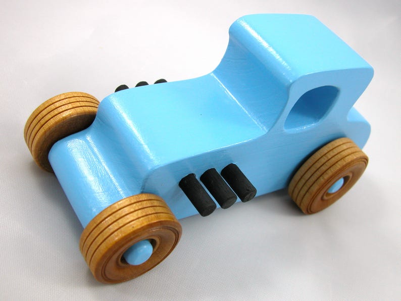 Handmade wooden toy car modeled after a '27 T-Coupe, finished with baby blue and black acrylic paint with nonmarring amber shellac wheels from my hot rod collection.