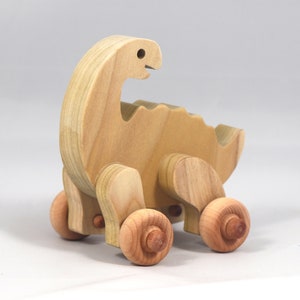 Handmade wooden push toy dinosaur made from select grade hardwoods and finished with a non-toxic coating.