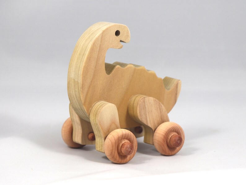 Handmade wooden push toy dinosaur made from select grade hardwoods and finished with a non-toxic coating.