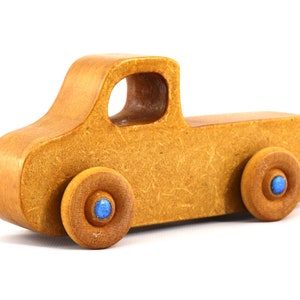 This handmade toy pickup truck from My Play Pal Collection is finished with amber shellac and metallic sapphire blue acrylic paint. It is just one of many unique wooden vehicles available.