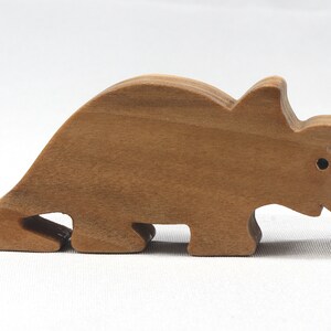 This small wooden triceratops dinosaur toy is crafted from high-quality hardwood and hand-finished. It is a delightful plaything for young children and appeals to many adults.