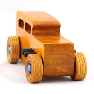 Handcrafted wooden hot rod toy car modeled after a classic '32 sedan. Finished with amber shellac and adorned with metallic sapphire blue and black trim. This unique piece is part of my Hot Rod Collection.