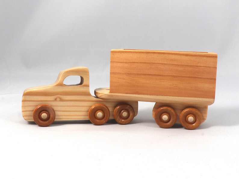 Handmade wooden toy tractor trailer semi truck finished with clear shellac. Crafted from natural wood using traditional woodworking tools. Approximate size 7 inches long. Made in Tallahassee, Florida, USA from Odin's Toy Factory Play Pal Collection.