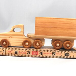 Handmade wooden toy tractor trailer semi truck finished with clear shellac. Crafted from natural wood using traditional woodworking tools. Approximate size 7 inches long. Made in Tallahassee, Florida, USA from Odin's Toy Factory Play Pal Collection.