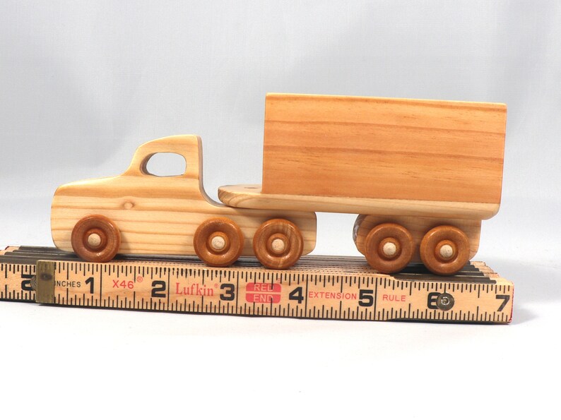 Handmade wooden toy tractor trailer semi truck finished with clear shellac. Crafted from natural wood using traditional woodworking tools. Approximate size 7 inches long. Made in Tallahassee, Florida, USA from Odin's Toy Factory Play Pal Collection.