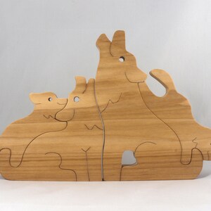 Wooden Wolf Family Stacking Puzzle is handmade from hardwood and finished with mineral oil, beeswax, and carnauba wax. Freestanding interlocking wolf family puzzle pieces shown assembled. Approximate size 10.5 inches long by 6.7 inches high by 3/4 inch thick. Handmade in Tallahassee, Florida, USA.