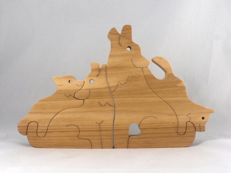 Wooden Wolf Family Stacking Puzzle is handmade from hardwood and finished with mineral oil, beeswax, and carnauba wax. Freestanding interlocking wolf family puzzle pieces shown assembled. Approximate size 10.5 inches long by 6.7 inches high by 3/4 inch thick. Handmade in Tallahassee, Florida, USA.