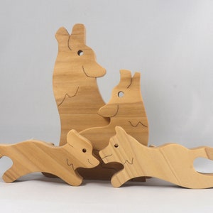 Wooden Wolf Family Stacking Puzzle is handmade from hardwood and finished with mineral oil, beeswax, and carnauba wax. Freestanding interlocking wolf family puzzle pieces shown assembled. Approximate size 10.5 inches long by 6.7 inches high by 3/4 inch thick. Handmade in Tallahassee, Florida, USA.