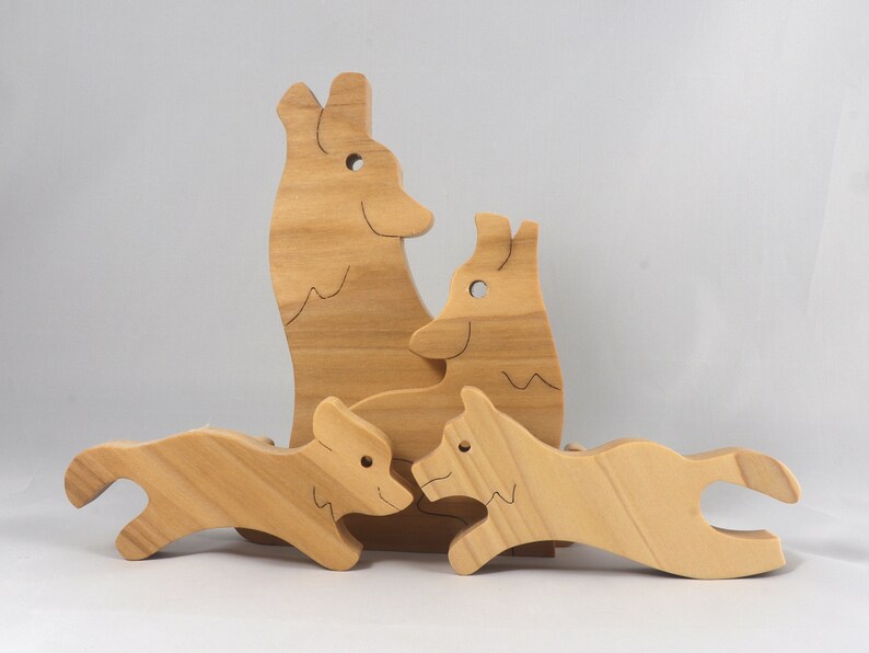 Wooden Wolf Family Stacking Puzzle is handmade from hardwood and finished with mineral oil, beeswax, and carnauba wax. Freestanding interlocking wolf family puzzle pieces shown assembled. Approximate size 10.5 inches long by 6.7 inches high by 3/4 inch thick. Handmade in Tallahassee, Florida, USA.