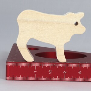 Handmade unfinished wooden toy baby calf cutout, unpainted and ready to paint, freestanding farm animal figure from Odin's Toy Factory’s  Itty Bitty Animal Collection. Handcrafted in Tallahassee, Florida, USA, using reclaimed natural wood offcuts. Perfect for imaginative play, stacking, collectors, and crafting.