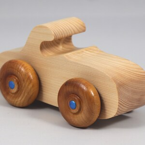Handmade wooden toy car. The body is finished with clear shellac, and the wheels are finished with amber shellac. The hubs are painted with metallic sapphire blue trim.