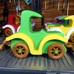 Handmade wooden toy car, vintage-style Model T sedan, painted bright green and yellow with spoked wheels, finished in amber shellac.  Handcrafted in Tallahassee, Florida, USA by Odin's Toy Factory.