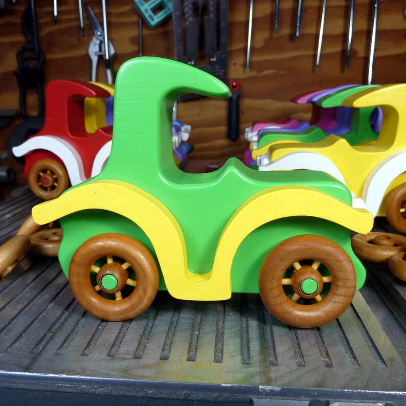 Handmade wooden toy car, vintage-style Model T sedan, painted bright green and yellow with spoked wheels, finished in amber shellac.  Handcrafted in Tallahassee, Florida, USA by Odin's Toy Factory.