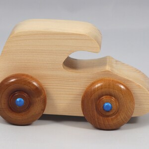 Handmade wooden toy car. The body is finished with clear shellac, and the wheels are finished with amber shellac. The hubs are painted with metallic sapphire blue trim.