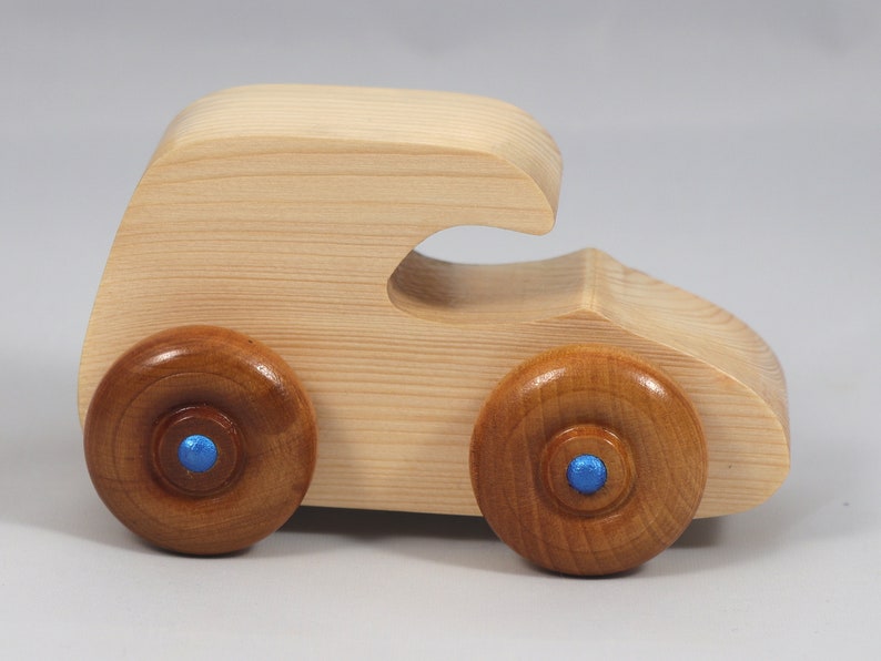 Handmade wooden toy car. The body is finished with clear shellac, and the wheels are finished with amber shellac. The hubs are painted with metallic sapphire blue trim.