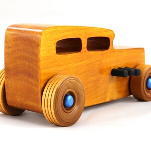 Handcrafted wooden hot rod toy car modeled after a classic '32 sedan. Finished with amber shellac and adorned with metallic sapphire blue and black trim. This unique piece is part of my Hot Rod Collection.