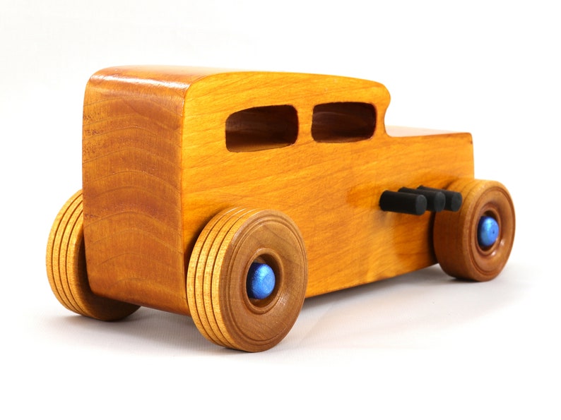 Handcrafted wooden hot rod toy car modeled after a classic '32 sedan. Finished with amber shellac and adorned with metallic sapphire blue and black trim. This unique piece is part of my Hot Rod Collection.