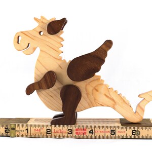Handmade wood baby dragon fantasy animal figurine made from select grade contrasting hardwoods and hand finished with a durable custom blend of mineral oil and waxes.