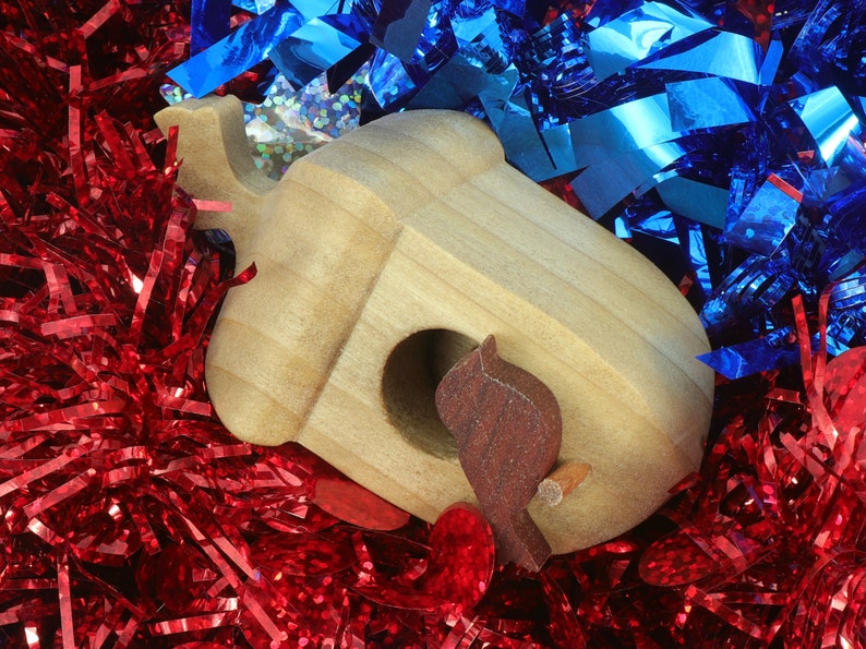 Handmade wooden miniature birdhouse ornament cut from wood with rounded edges, natural wood grain and color variations, finished with non-toxic shellac or food-safe oils and beeswax, lightweight and ready to hang. Made in Tallahassee, Florida, USA, by Odin's Toy Factory.