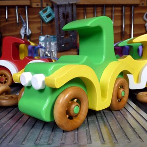 Handmade wooden toy car, vintage-style Model T sedan, painted bright green and yellow with spoked wheels, finished in amber shellac.  Handcrafted in Tallahassee, Florida, USA by Odin's Toy Factory.