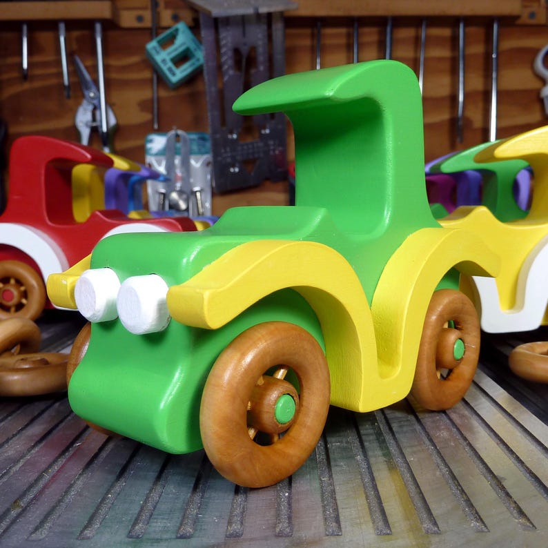 Handmade wooden toy car, vintage-style Model T sedan, painted bright green and yellow with spoked wheels, finished in amber shellac.  Handcrafted in Tallahassee, Florida, USA by Odin's Toy Factory.