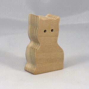 A handmade freestanding wooden toy cat cutout 1/2-3/4 inches thick is made from various kinds of wood sanded smooth and ready to paint. It is excellent for kids' crafts, pretend, or stacking toys. Other sizes are available with a custom order.