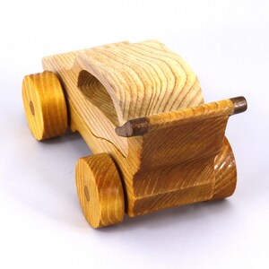 Handmade wooden toy car finished with nontoxic clear amber shellac and contrasting wood trim. Part of the Speedy Wheels Collection. Handcrafted in Tallahassee, Florida, USA. Length 5-1/2 inches, width 2-1/2 inches, height 2-1/2 inches. Made at Odin's Toy Factory.