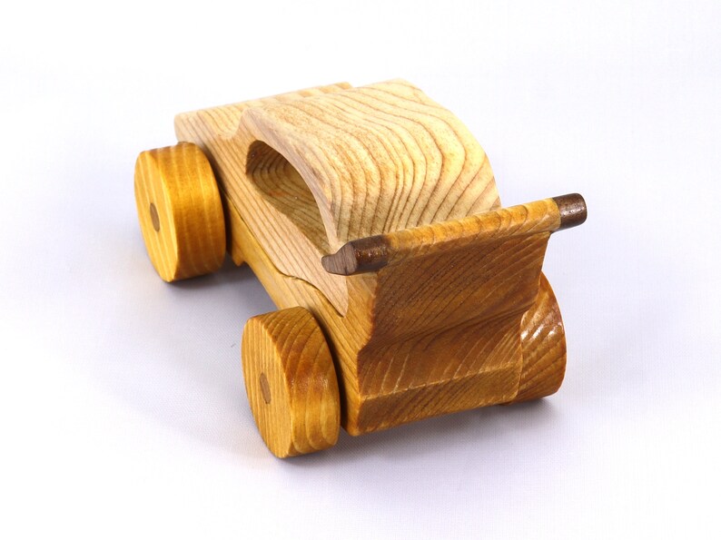 Handmade wooden toy car finished with nontoxic clear amber shellac and contrasting wood trim. Part of the Speedy Wheels Collection. Handcrafted in Tallahassee, Florida, USA. Length 5-1/2 inches, width 2-1/2 inches, height 2-1/2 inches. Made at Odin's Toy Factory.