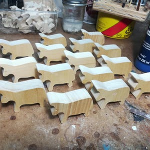 This is an unfinished wooden Cow cutout from solid wood using traditional woodworking techniques. Sanded smooth and ready to paint, stain, or customize. Freestanding design for small hands, toddlers, young children, crafters, collectors, and display. I take custom orders for any animal, quantity, and mix — including large ornament orders. Mix and match, request a different size, or send a drawing or pattern. Handmade by Odin's Toy Factory in Tallahassee, Florida, USA.