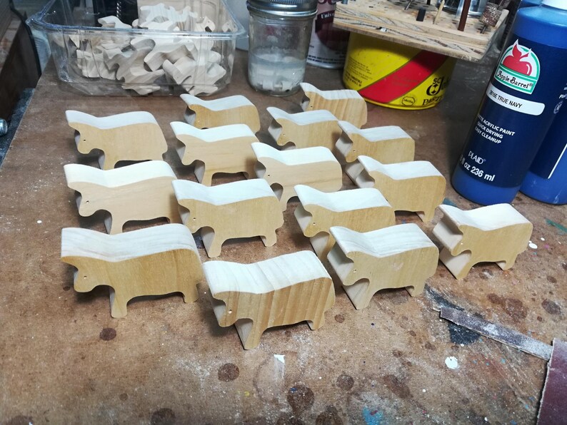 This is an unfinished wooden Cow cutout from solid wood using traditional woodworking techniques. Sanded smooth and ready to paint, stain, or customize. Freestanding design for small hands, toddlers, young children, crafters, collectors, and display. I take custom orders for any animal, quantity, and mix — including large ornament orders. Mix and match, request a different size, or send a drawing or pattern. Handmade by Odin's Toy Factory in Tallahassee, Florida, USA.