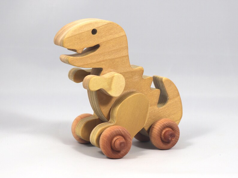 Handmade wooden push toy Tyrannosaurus Rex dinosaur made from select grade hardwoods and finished with a non-toxic coating.