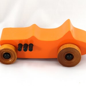 Handmade wooden toy car modeled after a 1927 T-Bucket hot rod. Finished with orange and black acrylic paint and amber shellac.