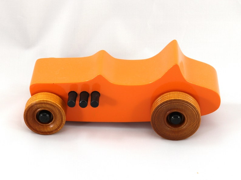 Handmade wooden toy car modeled after a 1927 T-Bucket hot rod. Finished with orange and black acrylic paint and amber shellac.