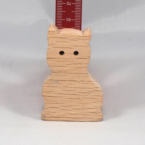 A handmade freestanding wooden toy cat cutout 1/2-3/4 inches thick is made from various kinds of wood sanded smooth and ready to paint. It is excellent for kids' crafts, pretend, or stacking toys. Other sizes are available with a custom order.