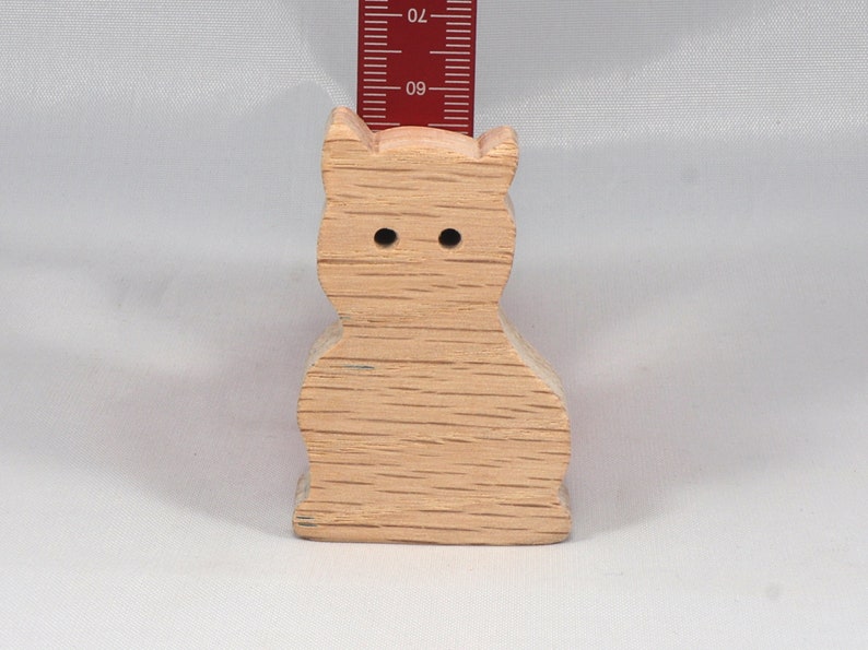A handmade freestanding wooden toy cat cutout 1/2-3/4 inches thick is made from various kinds of wood sanded smooth and ready to paint. It is excellent for kids' crafts, pretend, or stacking toys. Other sizes are available with a custom order.
