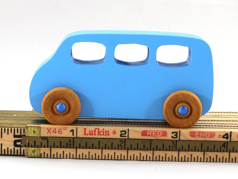 A Handmade wood toy mini van hand-painted baby blue with metallic sapphire blue trim and wheels finished with nonmarring amber shellac from my Play Pall Collection.