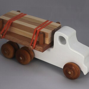 Handmade wooden toy lumber truck from Odin's Toy Factory Easy 5 Truck Fleet Collection. Painted lumber truck with acrylic body, shellac bed, and wheels. Measures approximately 9 inches long, 4 inches high, and 3.5 inches wide. Handmade in Tallahassee, Florida, USA. Custom colors available.