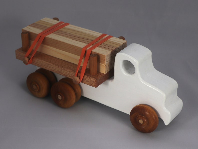 Handmade wooden toy lumber truck from Odin's Toy Factory Easy 5 Truck Fleet Collection. Painted lumber truck with acrylic body, shellac bed, and wheels. Measures approximately 9 inches long, 4 inches high, and 3.5 inches wide. Handmade in Tallahassee, Florida, USA. Custom colors available.