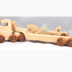 Handmade wooden toy truck play set includes three cars and a tractor-trailer finished with clear and amber shellac with metallic sapphire blue trim.